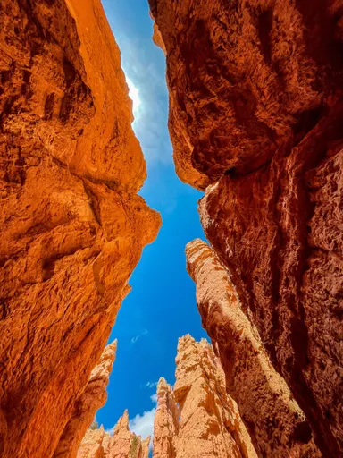 Cañón con formaciones rocosas rojizas y cielo azul.