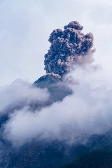 Erupción volcánica con fumarola de ceniza.